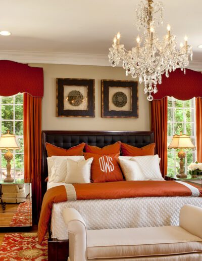 A red and white bedroom with a chandelier.