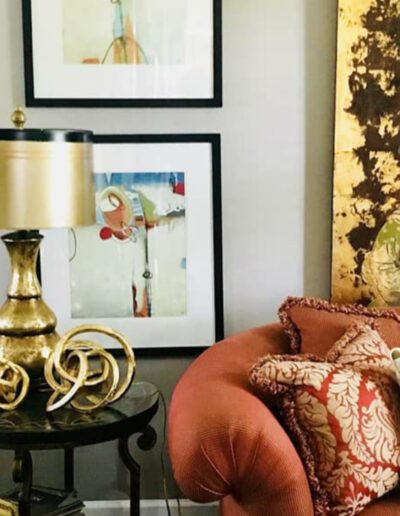 A living room with an orange couch and a gold lamp.